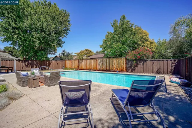 a view of a chairs and table in the back yard of the house