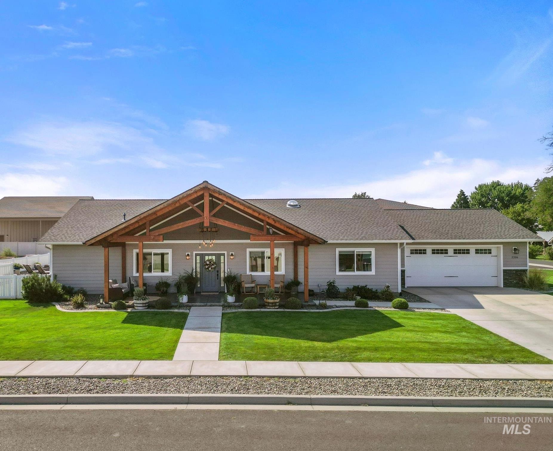View of front of home with covered porch, driveway, roof with shingles, and an attached garage