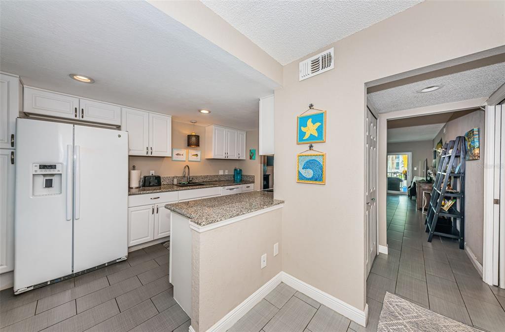 8699 Bardmoor Boulevard, Unit 203 Seminole, FL 33777 - Photo 3 of 14 a kitchen with a refrigerator a stove top oven and a refrigerator