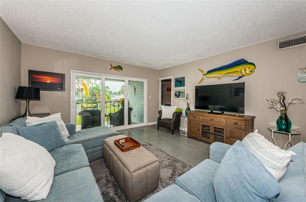 8699 Bardmoor Boulevard, Unit 203 Seminole, FL 33777 - Photo 5 of 14 a living room with furniture and a flat screen tv