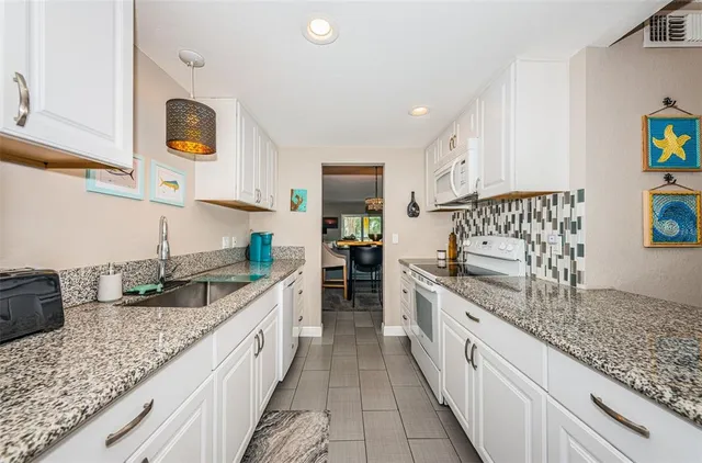 a kitchen with stainless steel appliances granite countertop a sink and a stove