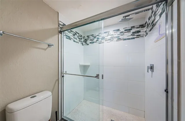 a bathroom with a shower a toilet and sink