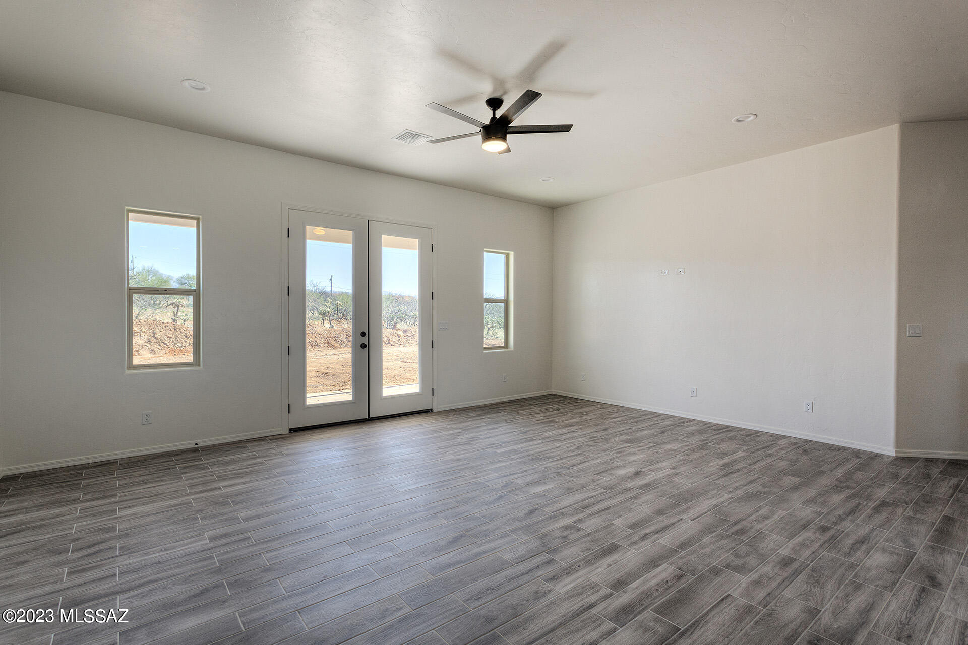1813 Cajeme Court Rio Rico, AZ 85648 - Photo 4 of 15 an empty room with wooden floor and windows