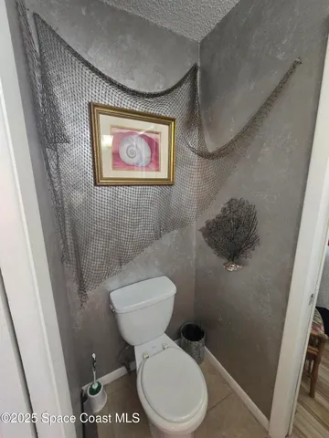 a white toilet sitting next to a small bathroom sink and vanity