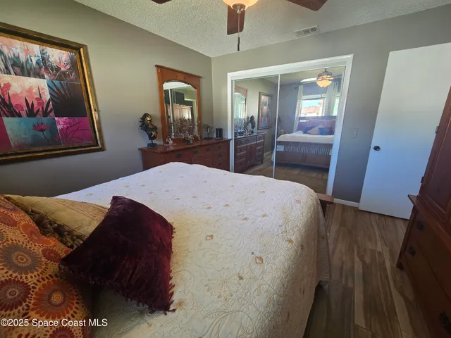 a living room with a bed and a view of kitchen
