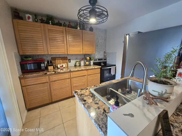 a kitchen with stainless steel appliances granite countertop a sink a stove and a wooden floor