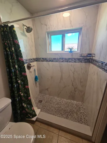 a view of bathroom with bathtub and shower