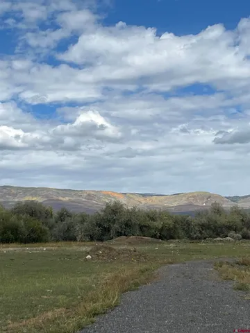 a view of grassy field with mountain