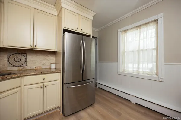 a kitchen with granite countertop white cabinets and refrigerator