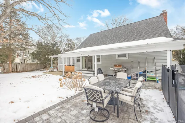 a patio with a table and chairs and potted plants