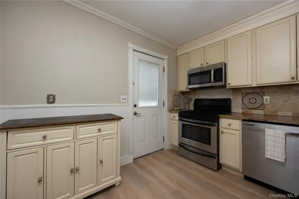 a kitchen with granite countertop white cabinets and stainless steel appliances