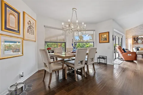 a view of a dining room with furniture a chandelier and wooden floor