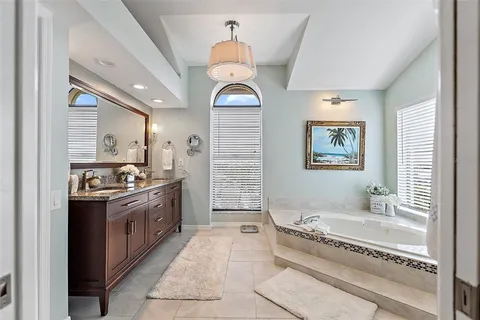 a bathroom with a tub shower and mirror