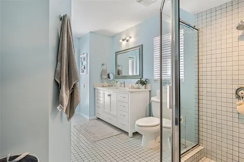 a bathroom with a double vanity sink toilet and a mirror