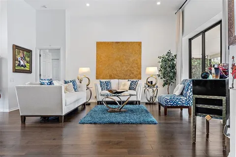 a living room with furniture floor to ceiling window and wooden floor