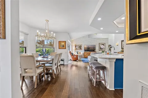 a view of a dining room with furniture a chandelier and wooden floor