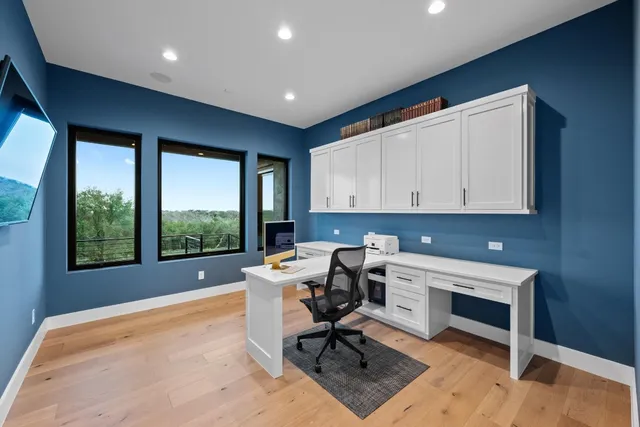 a work place with a large window and chair