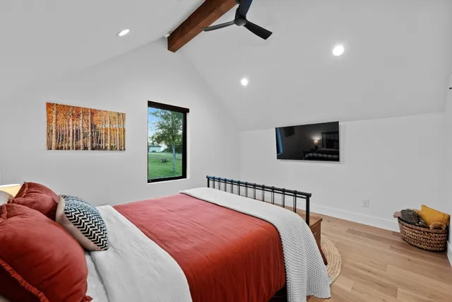 a bedroom with a bed and a flat screen tv