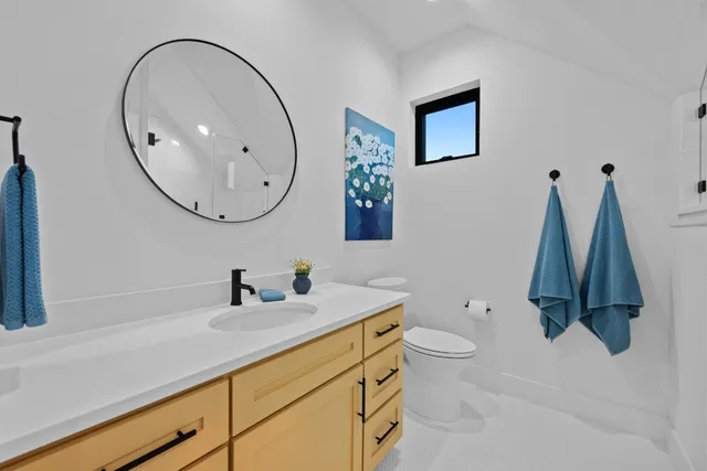 a bathroom with a sink a toilet and a mirror