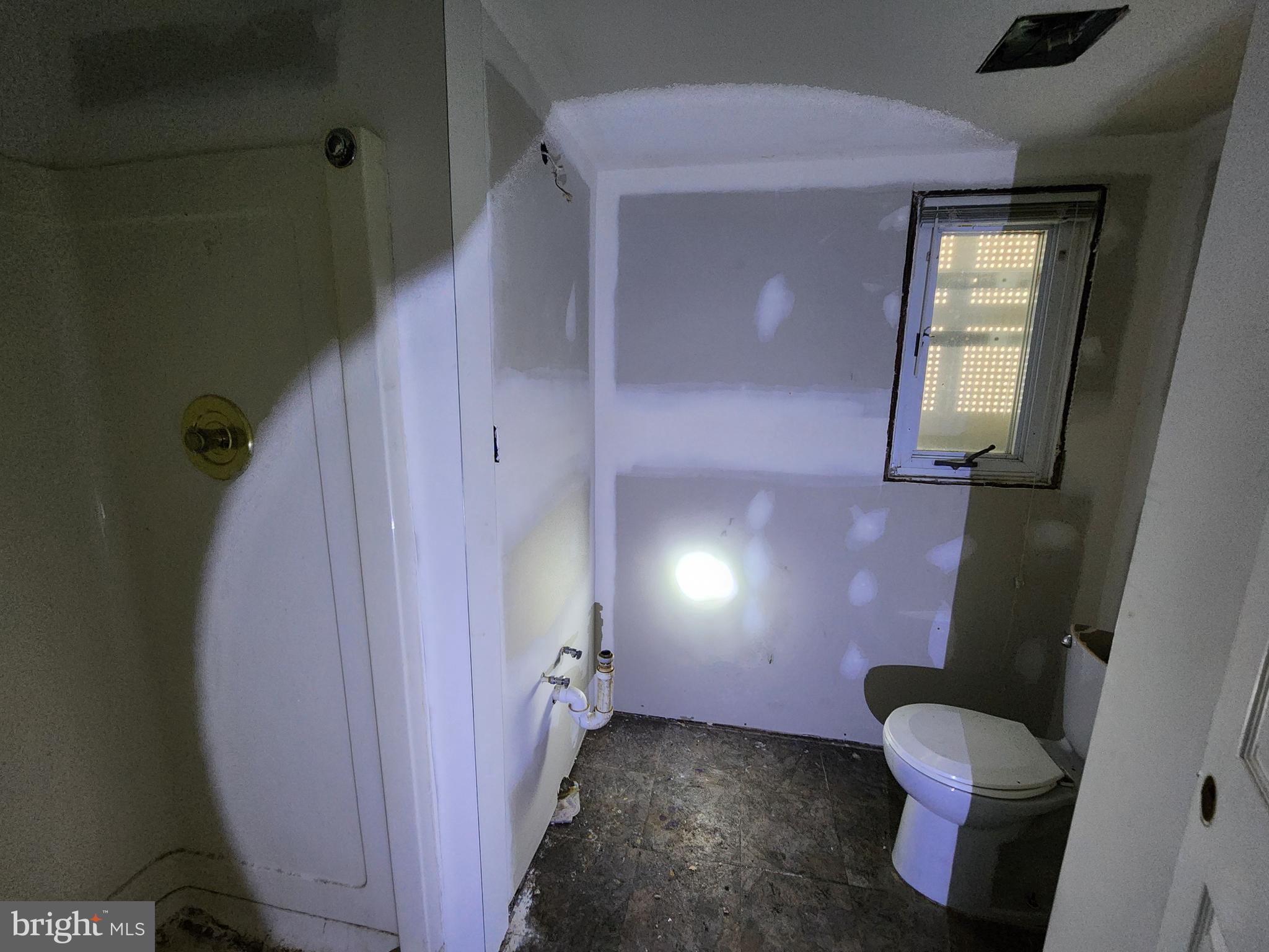 3425 6th Street Baltimore, MD 21225 - Photo 9 of 35 a bathroom with a toilet mirror and vanity