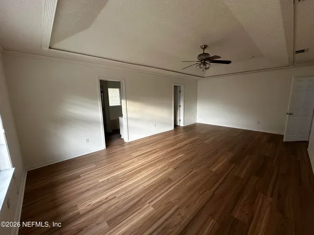a view of empty room with wooden floor