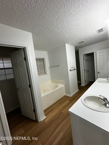 a view of a hallway to a livingroom with furniture wooden floor and staircase