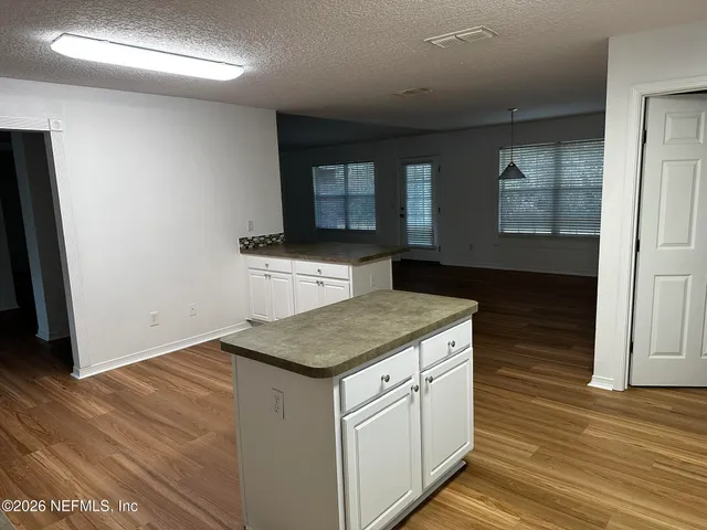 a kitchen with a stove and wooden floor