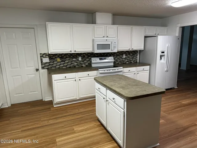 a kitchen with granite countertop a sink and a refrigerator