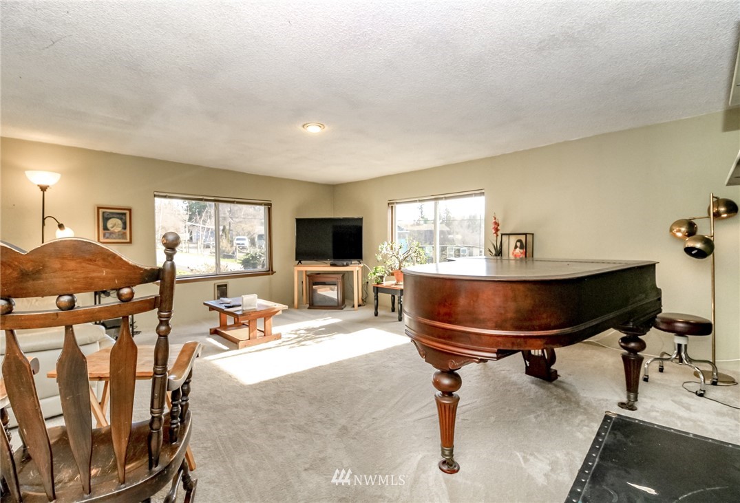 11804 County Line Road Edgewood, WA 98372 - Photo 3 of 19 a living room with furniture a flat screen tv and a table
