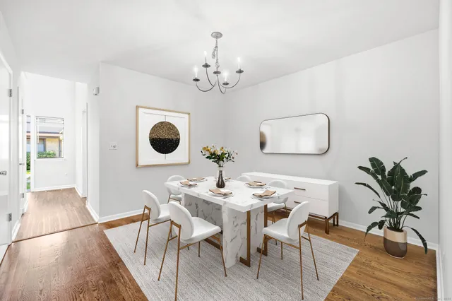a dining room with wooden floor a chandelier a wooden table and chairs