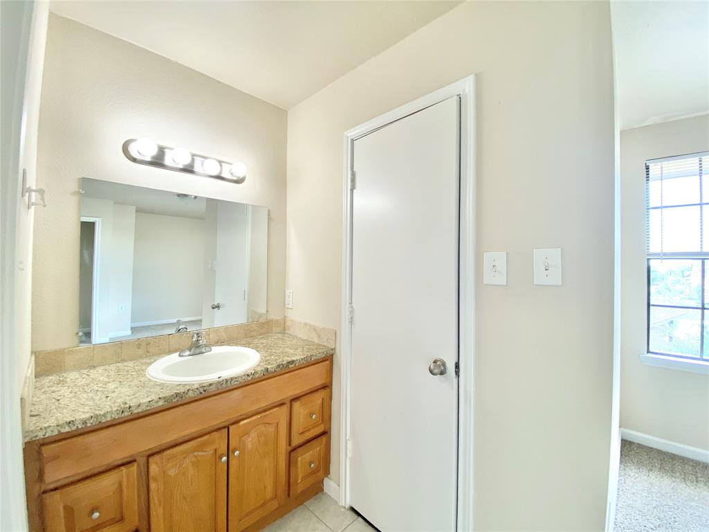 8001 C Rothington Road, Unit 21 Dallas, TX 75227 - Photo 19 of 32 a bathroom with a granite countertop sink and a mirror