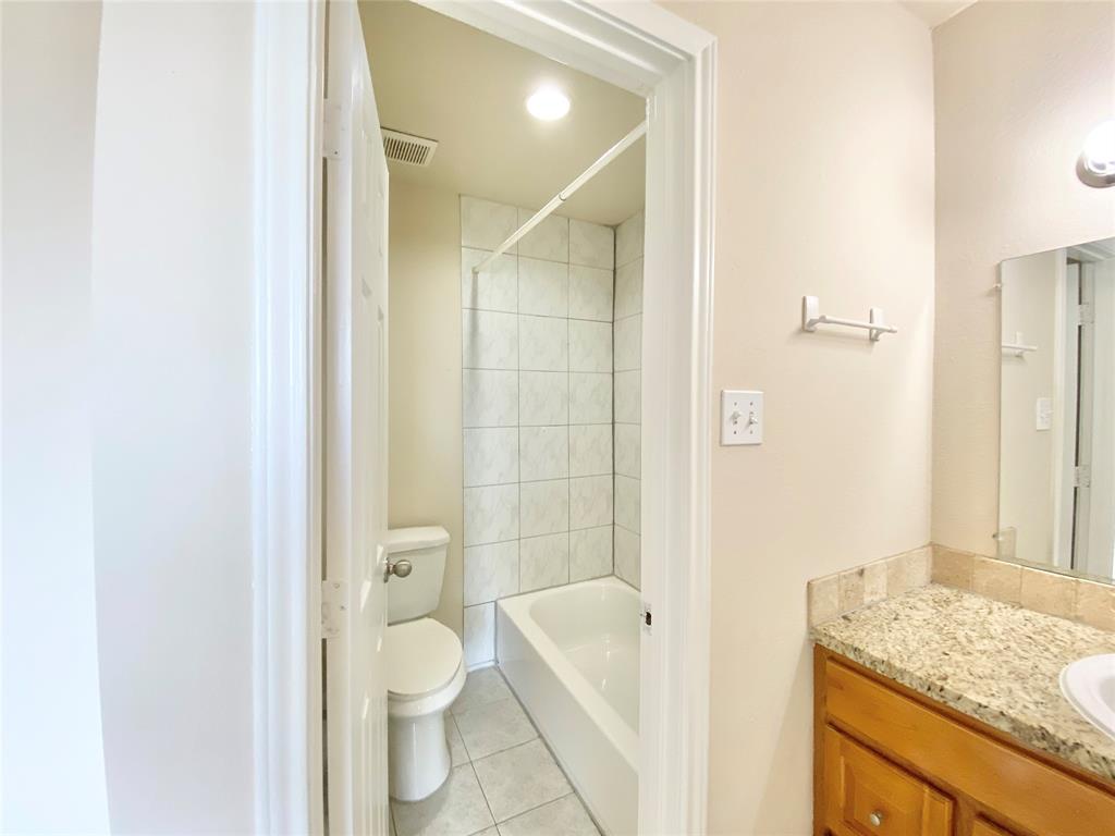 8001 C Rothington Road, Unit 21 Dallas, TX 75227 - Photo 20 of 32 a bathroom with a granite countertop toilet a sink and bathtub