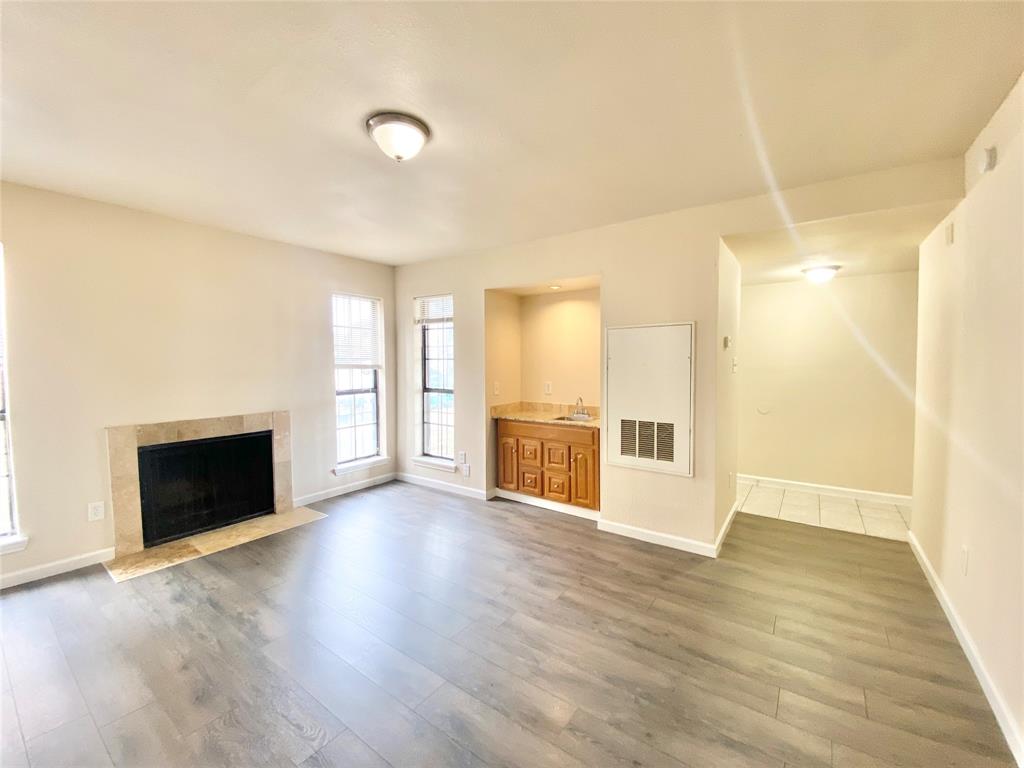 8001 C Rothington Road, Unit 21 Dallas, TX 75227 - Photo 3 of 32 a view of an empty room with wooden floor and a window