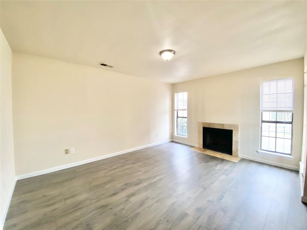 8001 C Rothington Road, Unit 21 Dallas, TX 75227 - Photo 4 of 32 an empty room with wooden floor fireplace and windows