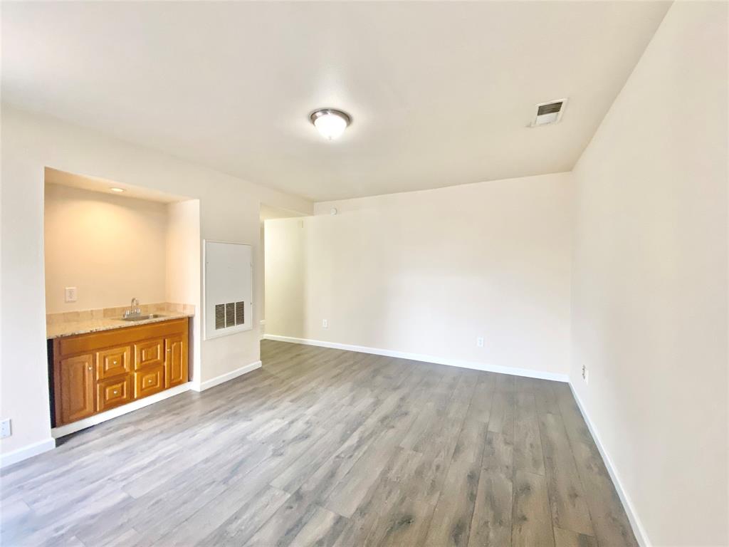 8001 C Rothington Road, Unit 21 Dallas, TX 75227 - Photo 5 of 32 an empty room with wooden floor and windows