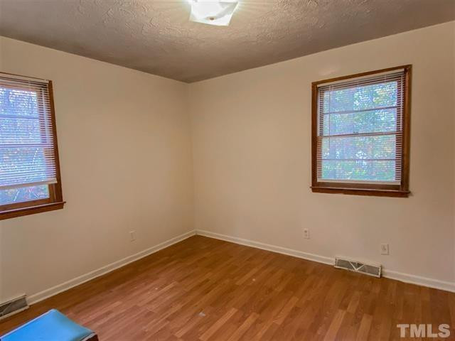 217 Lake Drive Roxboro, NC 27573 - Photo 7 of 20 a view of an empty room with wooden floor and a window