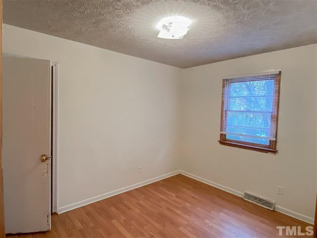 217 Lake Drive Roxboro, NC 27573 - Photo 8 of 20 a view of an empty room with a window and wooden floor