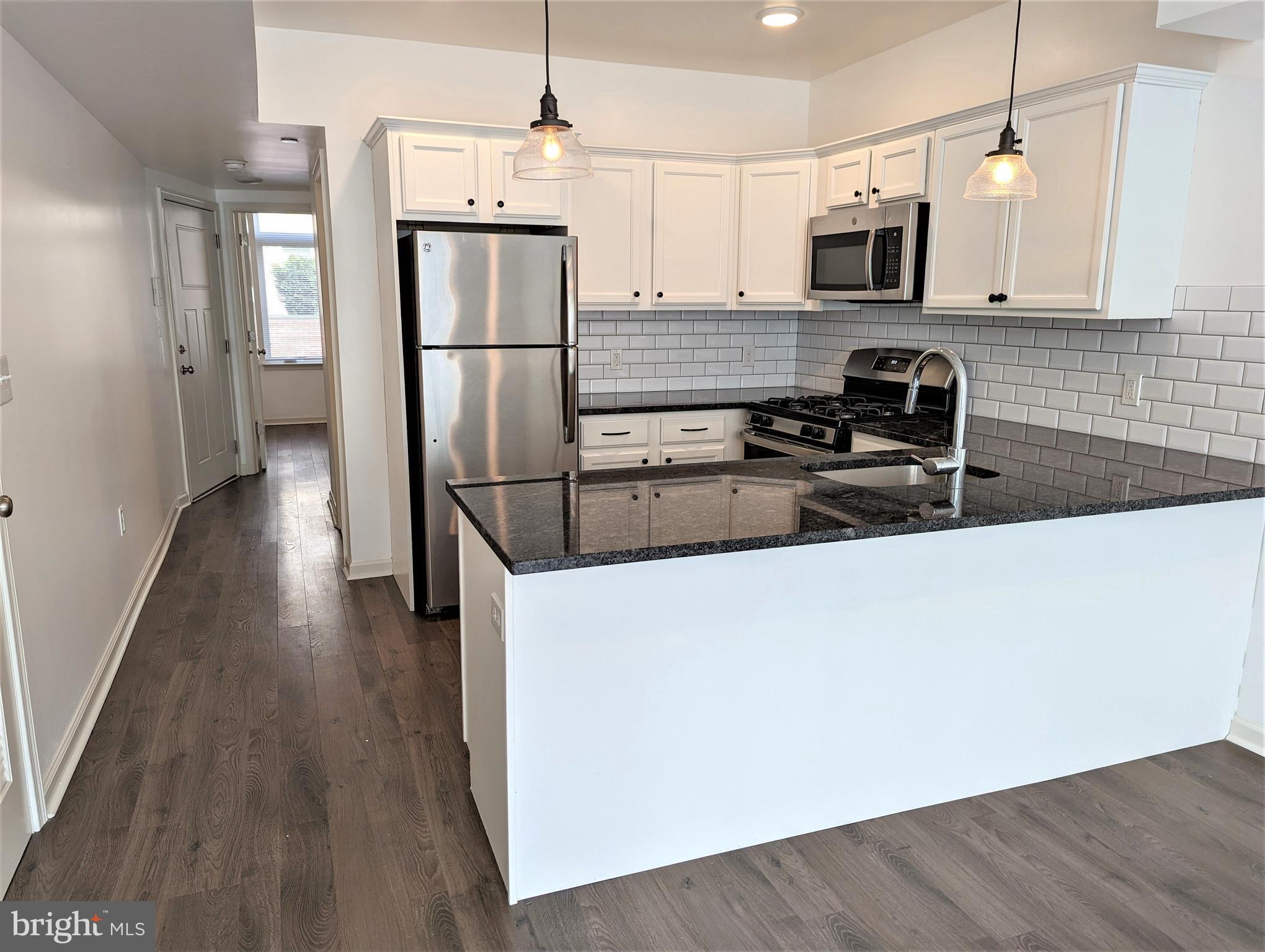 6615 Ridge Avenue, Unit 304 Philadelphia, PA 19128 - Photo 2 of 10 a kitchen with stainless steel appliances a refrigerator sink and microwave
