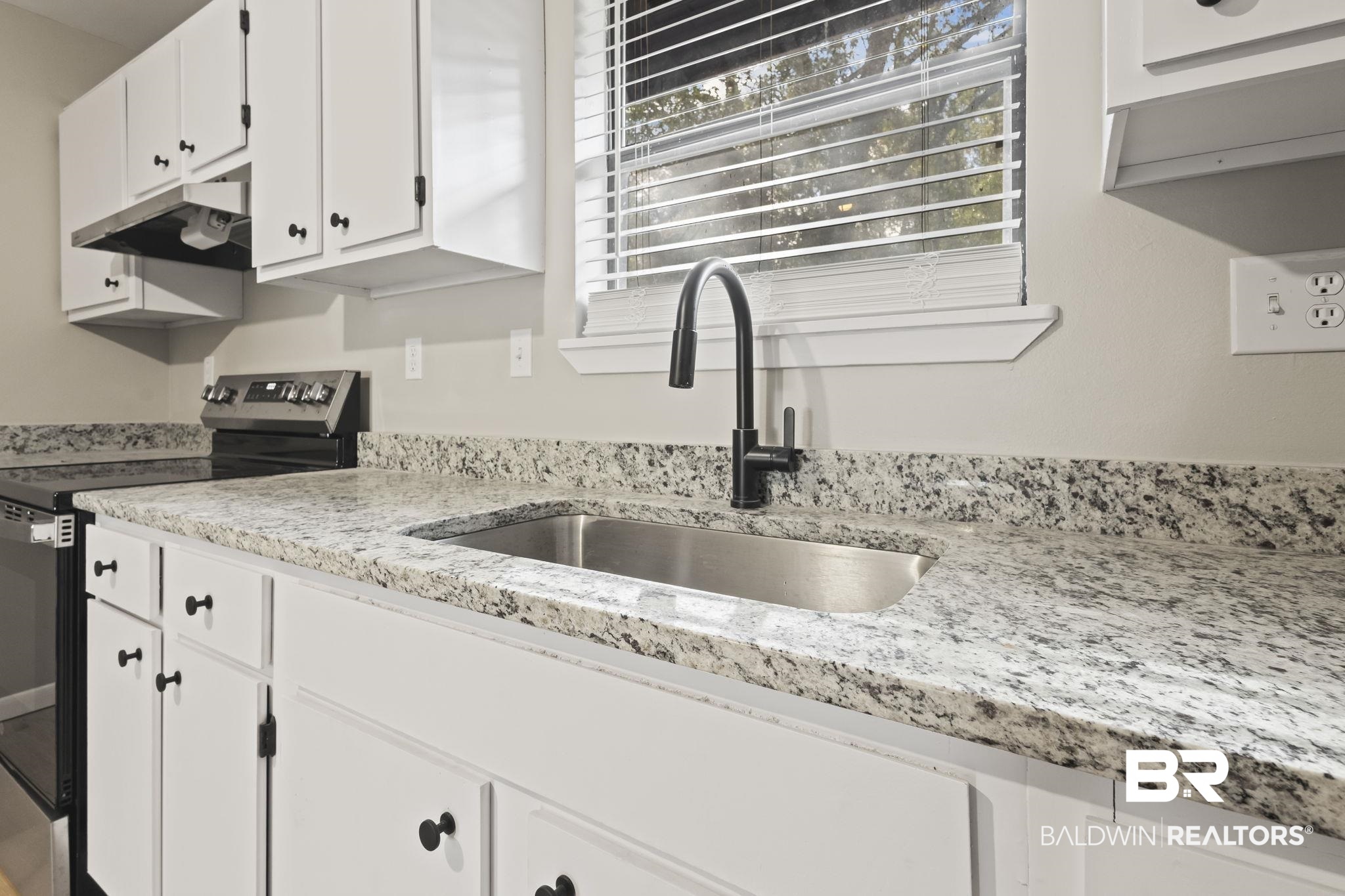 309 West Roosevelt Avenue Foley, AL 36535 - Photo 29 of 60 Kitchen featuring white cabinets, electric range, and sink