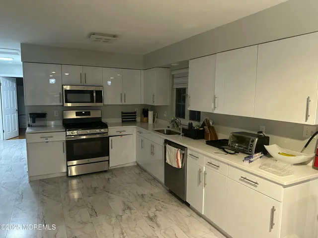 a kitchen with appliances a sink and cabinets
