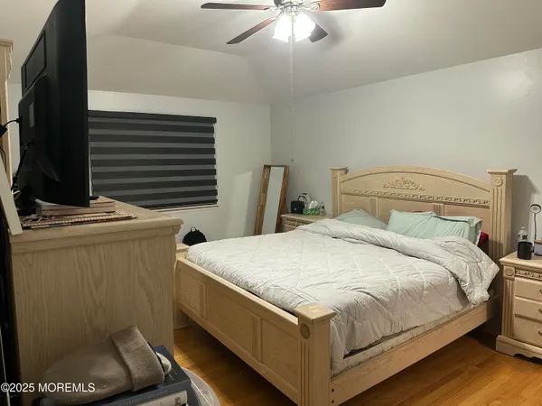 a bedroom with a bed and a flat tv screen on dresser