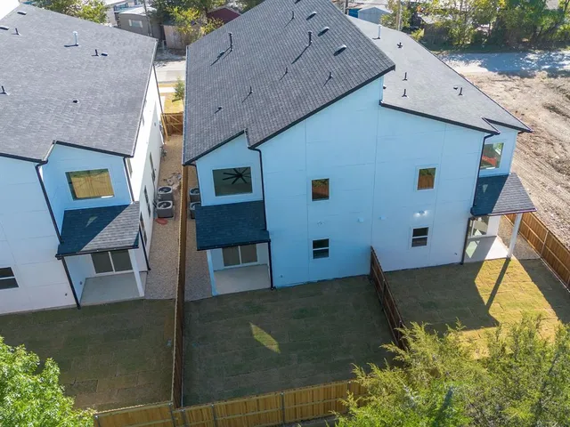 an aerial view of a house with swimming pool and wooden fence