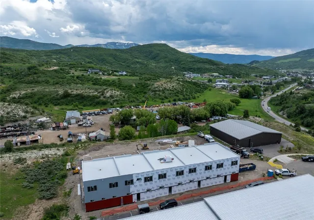 an aerial view of a house with a mountain