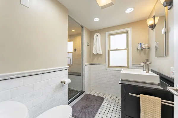 a bathroom with a sink a toilet a mirror and shower