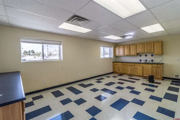 a room with a black white checkered floor furniture and a rug