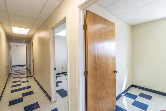 a view of a hallway with wooden floor and windows