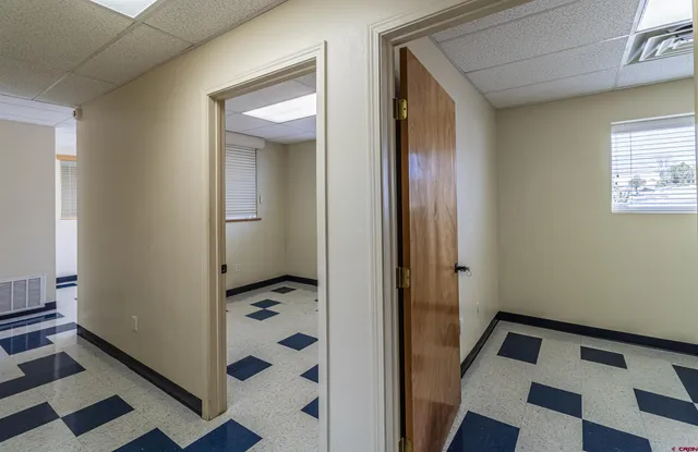 a walk in closet and view of bathroom with a sink