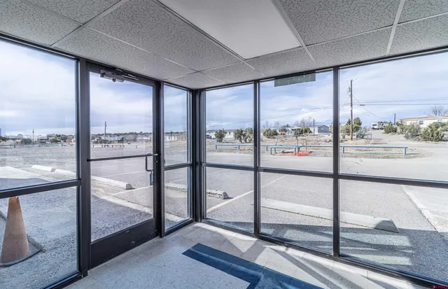 a view of an empty room with wooden floor and windows