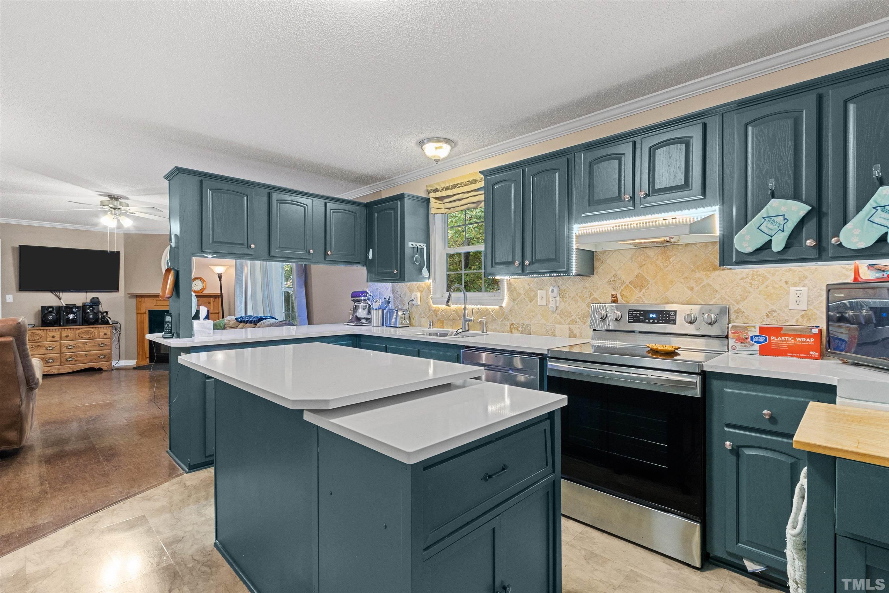 2710 Hurdover Road Apex, NC 27539 - Photo 11 of 52 a kitchen with stainless steel appliances granite countertop a sink stove and refrigerator