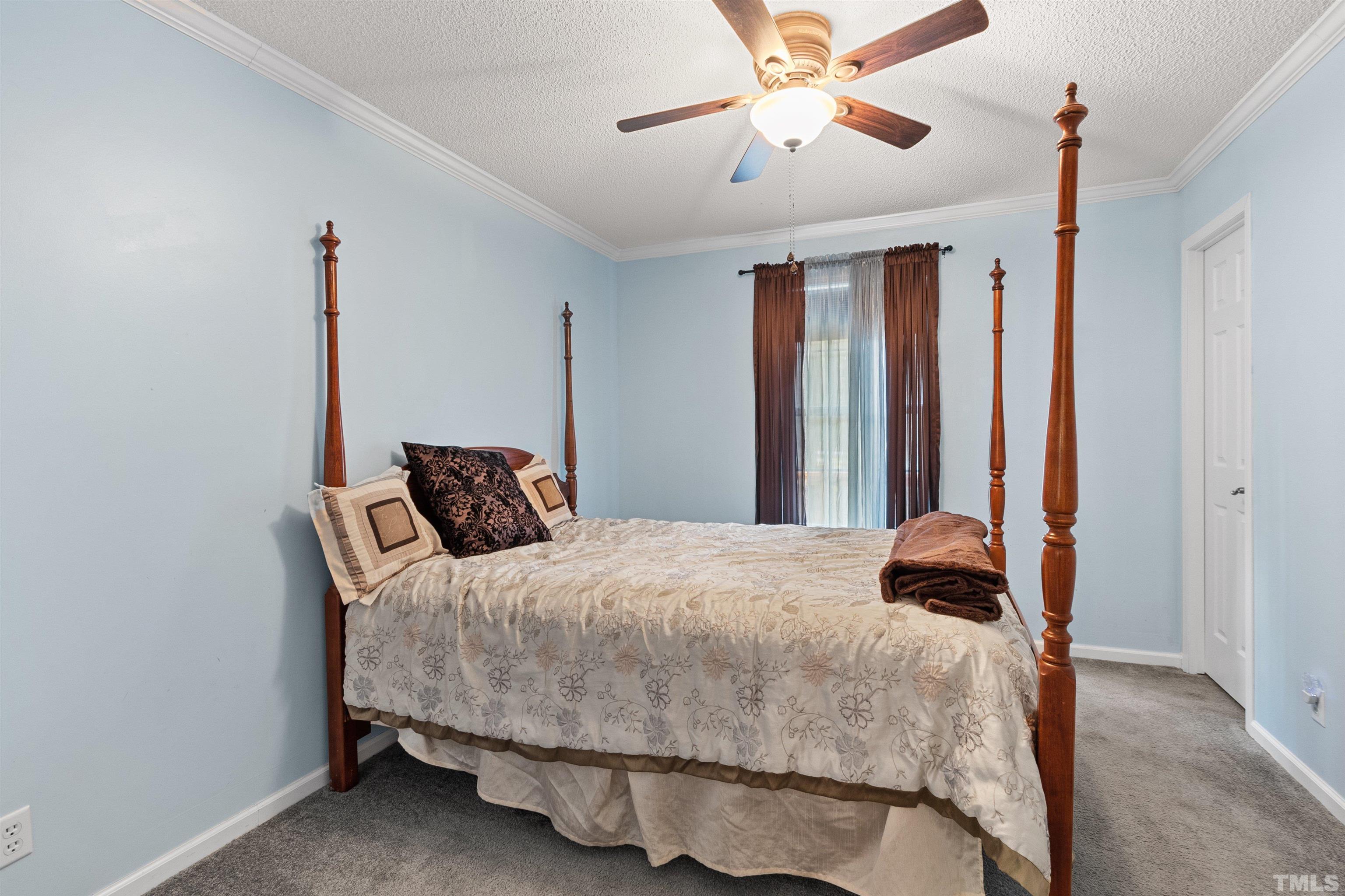 2710 Hurdover Road Apex, NC 27539 - Photo 25 of 52 a bedroom with a bed and a chandelier